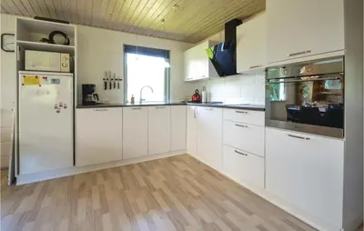 a kitchen with white cabinets and a refrigerator at Three-Bedroom Holiday Home In Hjerm in Hjerm