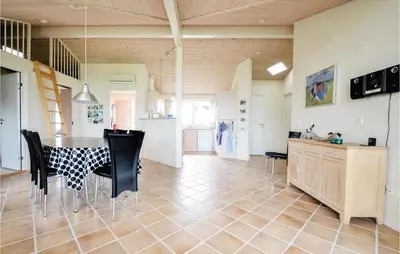 a kitchen and dining room with a table and chairs at Three-Bedroom Holiday Home In Vinderup in Vinderup