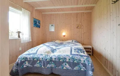 a bedroom with a bed with a quilt on it at Three-Bedroom Holiday Home In Vinderup in Vinderup