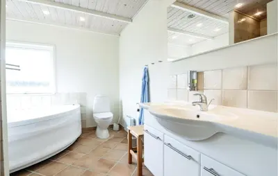 a bathroom with a tub and a sink and a toilet at Three-Bedroom Holiday Home In Vinderup in Vinderup