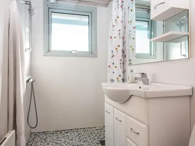 a white bathroom with a sink and a window at Cozy Beach House Retreat - By Traum Ferienwohnungen in Harboør