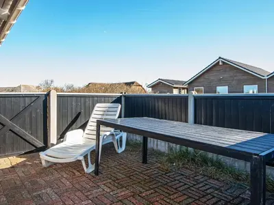 a picnic table and two chairs sitting on a patio at Cozy Beach House Retreat - By Traum Ferienwohnungen in Harboør