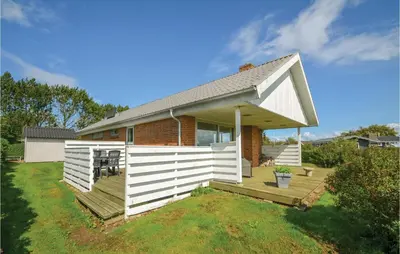 a small house with a white fence on a yard at Three-Bedroom Holiday Home In Hurup Thy in Doverodde