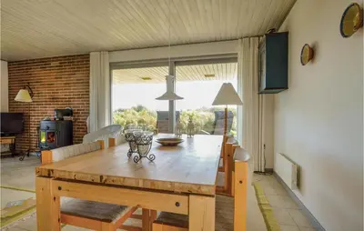 a dining room with a wooden table and a room with at Three-Bedroom Holiday Home In Hurup Thy in Doverodde