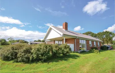 a brick house with a chimney on a lawn at Three-Bedroom Holiday Home In Hurup Thy in Doverodde