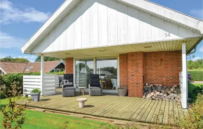 a house with a wooden deck in the yard at Three-Bedroom Holiday Home In Hurup Thy in Doverodde