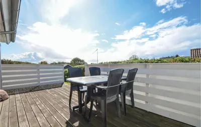 a table and chairs on the deck of a house at Three-Bedroom Holiday Home In Hurup Thy in Doverodde