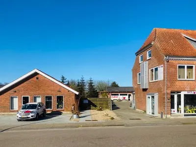 a car parked in a parking lot next to a brick building at Stor lys lejlighed på Nordmors in Sejerslev