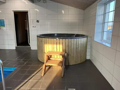 a wooden tub with a wooden chair in a bathroom at 24 person holiday home in Øster Assels in Øster Assels