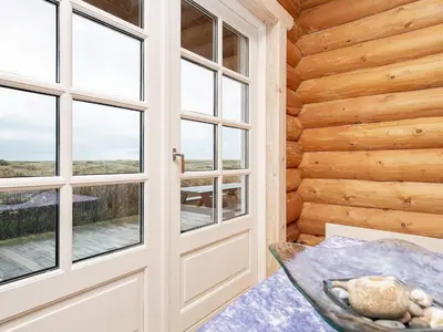 a door in a log cabin with windows at 10 person holiday home in Frøstrup-By Traum in Frøstrup