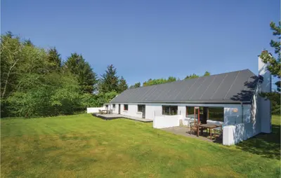 a white house with a gray roof and a yard at Three-Bedroom Holiday Home In Frostrup in Frøstrup