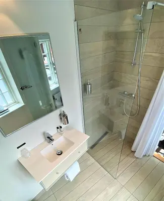 a bathroom with a sink and a shower at Hotel Skivehus in Skive