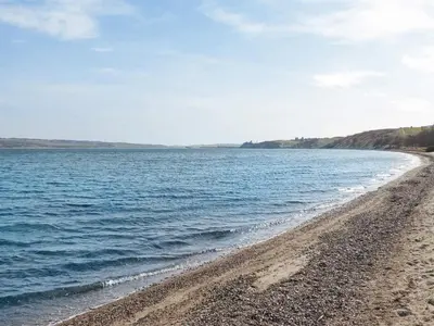 a beach with a rocky shore and the ocean at 6 person holiday home in Lemvig in Lemvig