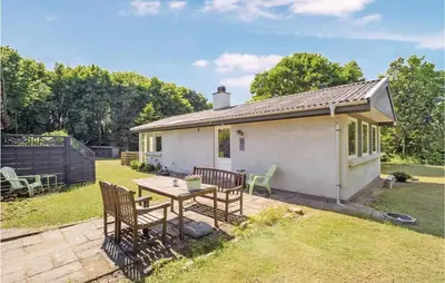 a small white house with a table and chairs at Two-Bedroom Holiday Home In Spottrup in Spottrup