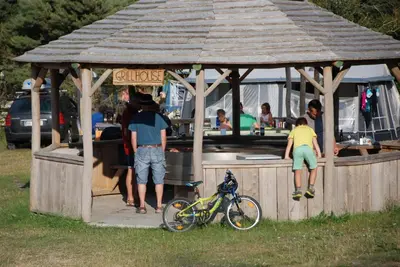 a group of people standing in a gazebo with a bike at Hytteby – Hanstholm Camping – Thy Feriepark in Hanstholm