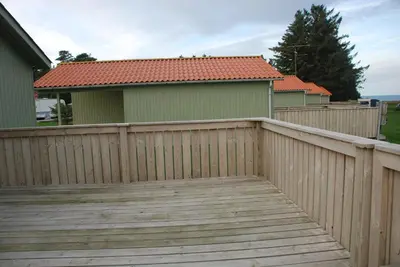 a wooden fence in front of a house at Hytteby – Hanstholm Camping – Thy Feriepark in Hanstholm