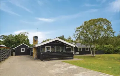 a home with a black house with a driveway at Five-Bedroom Holiday Home In Blokhus in Blokhus