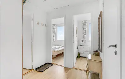 a white room with a bed and a mirror at Three-Bedroom Holiday Home In Lemvig in Lemvig