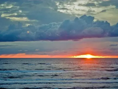 a sunset over the ocean with the sun setting at Seaside Serenity in Blokhus-By Traum in Blokhus