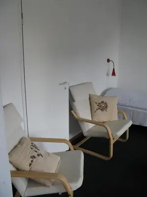 a room with two chairs and a bed at Motel Europa in Svenstrup