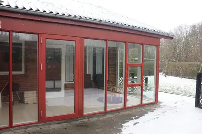 a red house with glass doors on the side of it at Holstebro Townside House in Holstebro