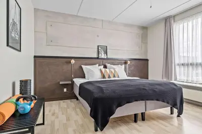 a bedroom with a large bed with a black blanket at Best Western Royal Holstebro in Holstebro