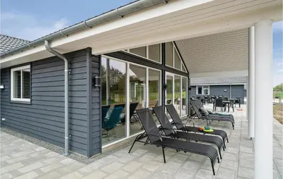 a screened in porch with chairs on a house at Nice Home In Spøttrup With Sauna in Spottrup