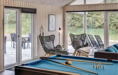 a living room with a pool table and chairs at Nice Home In Spøttrup With Sauna in Spottrup