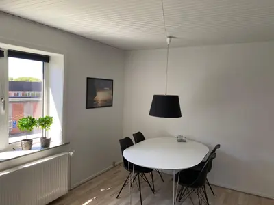 a dining room with a white table and chairs at Malthe Bruuns Vej 17, 1. sal in Thisted