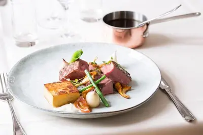 a white plate of food on a table at Tambohus Kro & Badehotel in Hvidbjerg