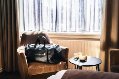 a purse sitting in a chair next to a window at Struer Grand Hotel in Struer