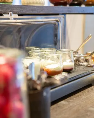 a toaster oven with several glasses of food in it at Struer Grand Hotel in Struer