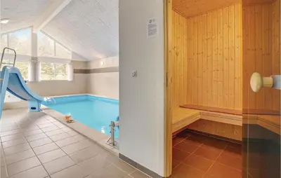 a swimming pool with a slide in a bathroom at Lovely Home In Spøttrup With Sauna in Spottrup