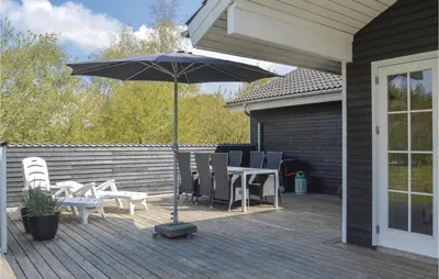 a patio with a table and chairs and an umbrella at Three-Bedroom Holiday Home In Logstor in Løgstør