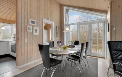a dining room with a table and black chairs at Three-Bedroom Holiday Home In Logstor in Løgstør