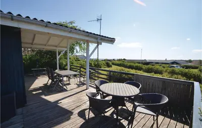 a patio with tables and chairs on a deck at Three-Bedroom Holiday Home In Hurup Thy in Doverodde