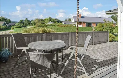 a porch with a table and chairs and a swing at Three-Bedroom Holiday Home In Hurup Thy in Doverodde