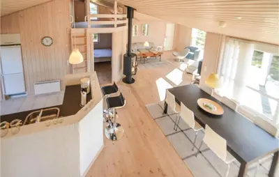 a kitchen and living room with a table and chairs at Four-Bedroom Holiday Home In Fjerritslev in Fjerritslev