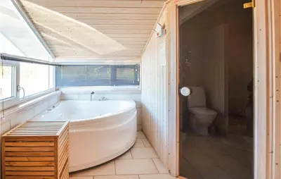 a bathroom with a tub and a toilet at Four-Bedroom Holiday Home In Fjerritslev in Fjerritslev
