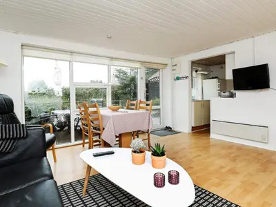 a living room with a white table and a kitchen at 4 person holiday home in Nykøbing M-By Traum in Refshammer