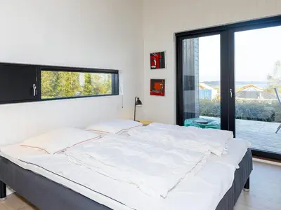 a large white bed in a room with a window at Modern Retreat with View - By Traum Ferienwohnungen in Løgstrup