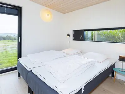 a bedroom with a bed and a large window at Modern Retreat with View - By Traum Ferienwohnungen in Løgstrup