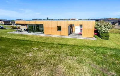 a small wooden house on a grass field at Two-Bedroom Holiday Home In Vinderup in Vinderup