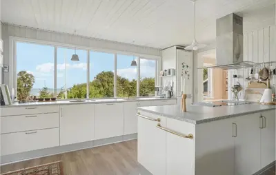 a kitchen with white cabinets and a large window at Three-Bedroom Holiday Home In Fur in Fur