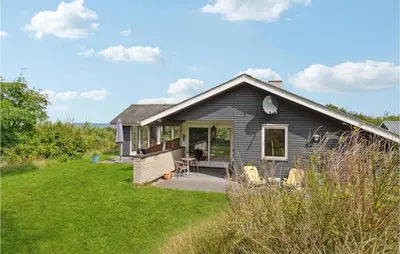 a gray house with a lawn in front of it at Three-Bedroom Holiday Home In Fur in Fur