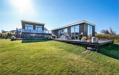a modern house with a large lawn in front of it at Two-Bedroom Holiday Home In Lemvig in Lemvig