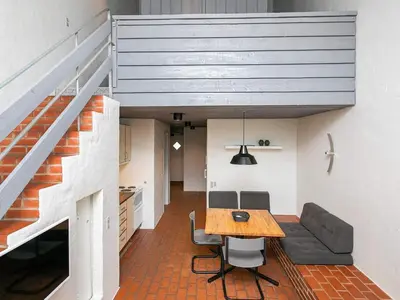 a living room with a dining room table and a staircase at 6 person holiday home in Brovst-By Traum in Brovst