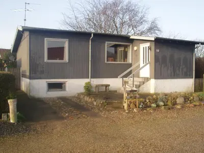 a small house with a fence next to it at 