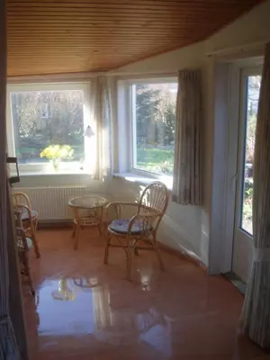 a room with chairs and a table and windows at 