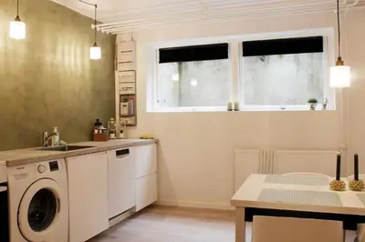 a kitchen with a washing machine and a window at Nordkap Bed & Bath in Holstebro